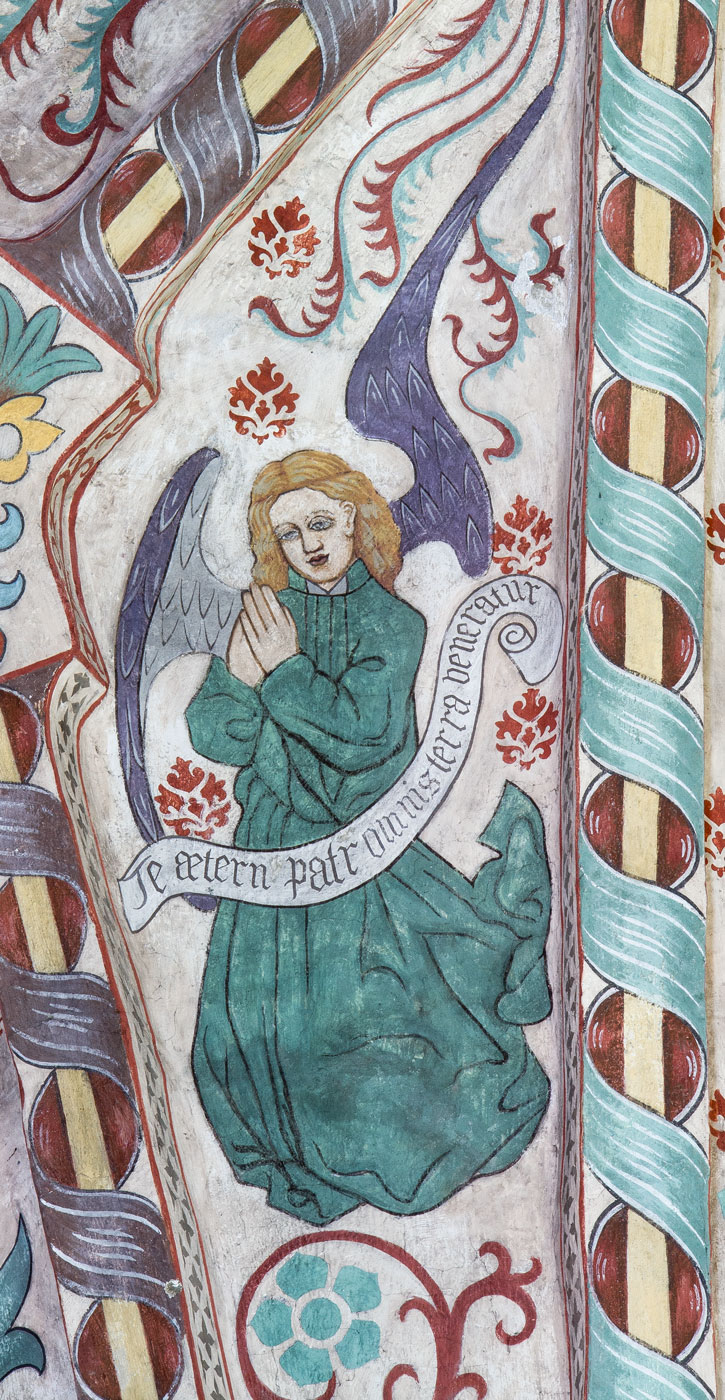 En av åtta änglar med hymnen Te Deum uppdelad på åtta språkband: Te aetern(um) patrem omnis terra veneratur (S) - Vittinge kyrka