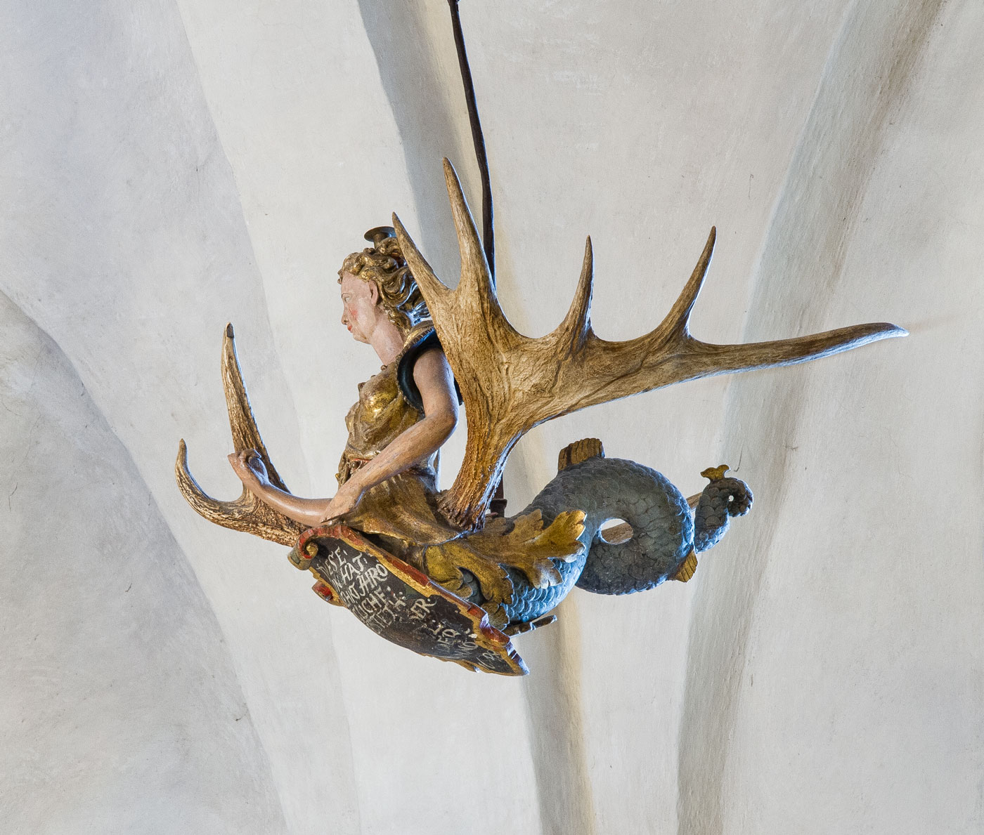 Ljuskrona, en sjöljungfru i trä med älghorn framväxande ur sidorna - Bromma kyrka