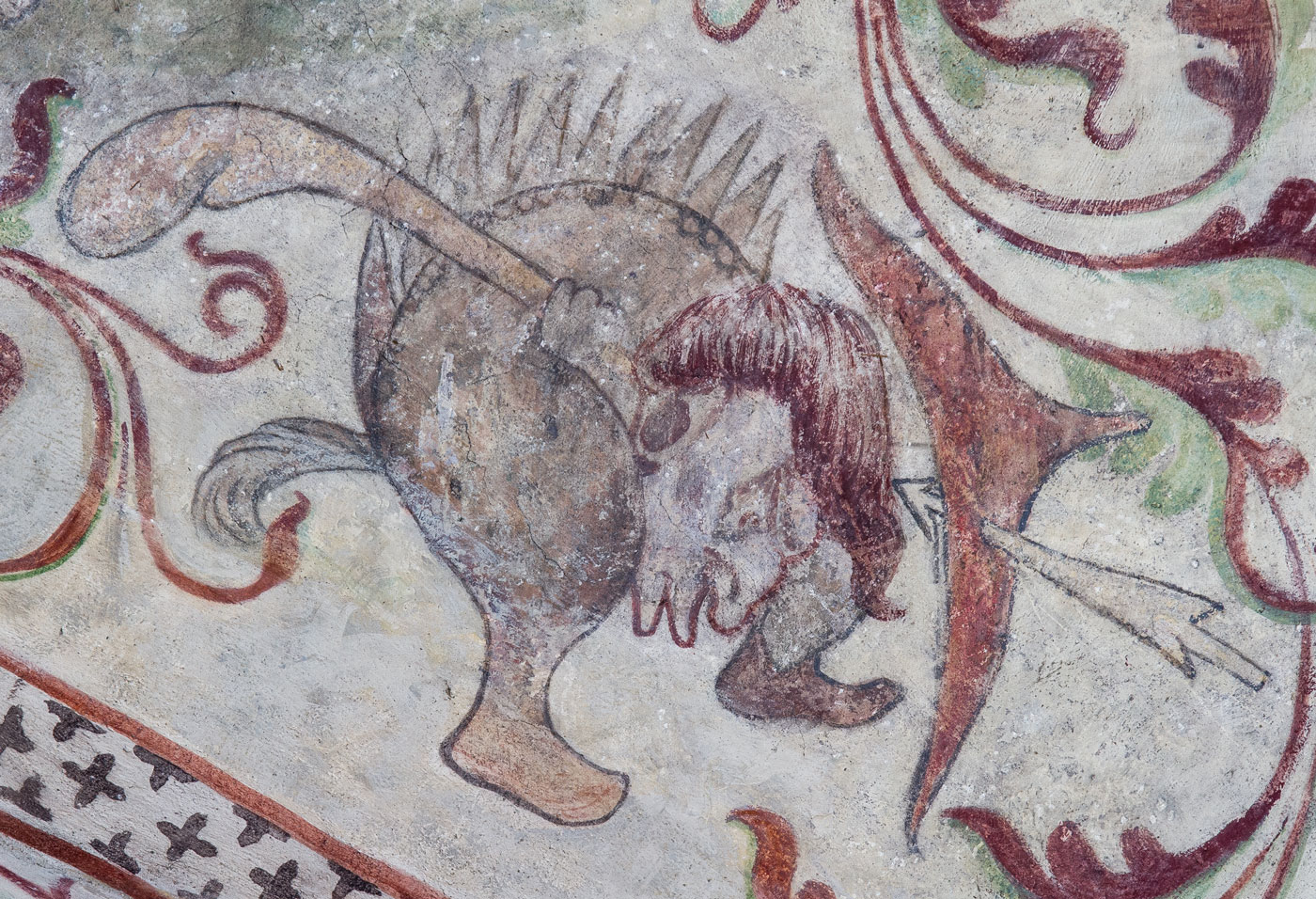 Detalj ur Ett slags svin, med människohuvud och skor på fötterna, och en motståndare i form av en vildman beväpnad med båge - Ösmo kyrka